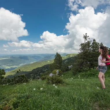 Randonneuse contemplant la vue lors de la randonnée itinérante dans les Monts Jura