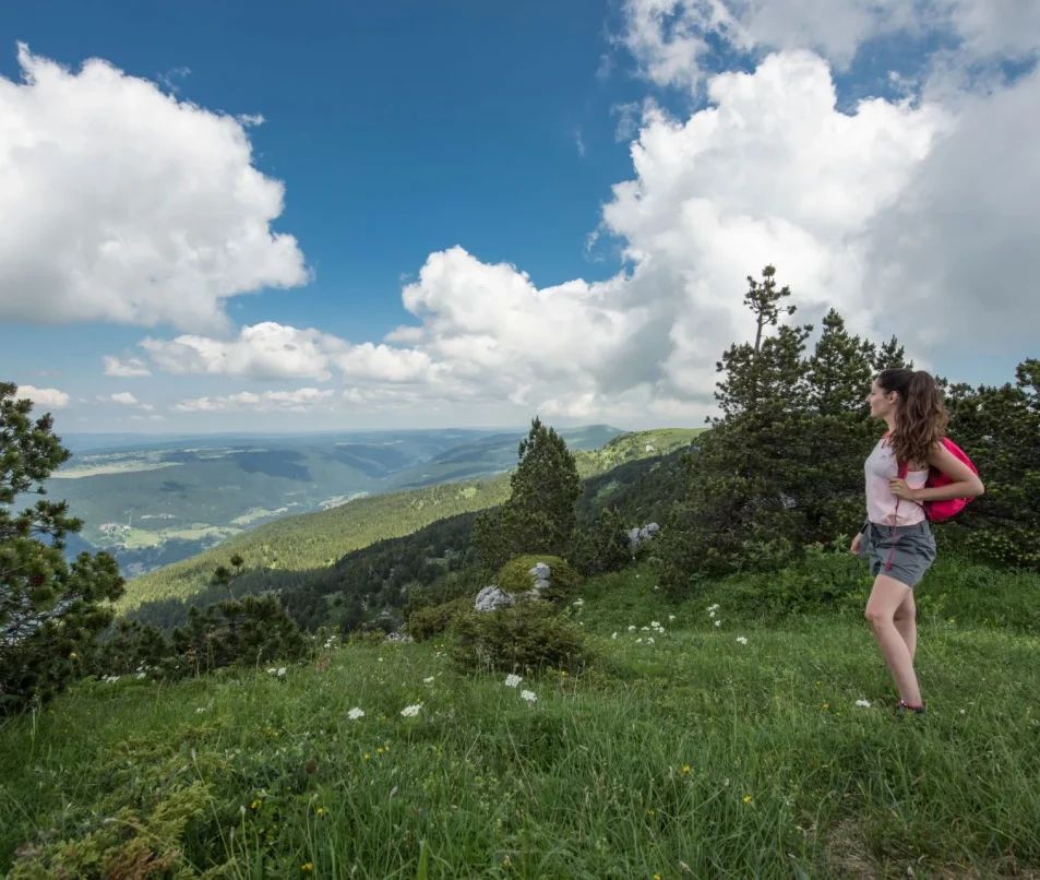 Randonneuse contemplant la vue lors de la randonnée itinérante dans les Monts Jura